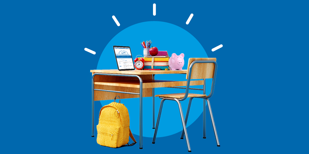 Man sieht einen Arbeitsplatz in der Schule mit Büchern drauf. Ein gelber Rucksack ist an den Stuhl gelehnt.