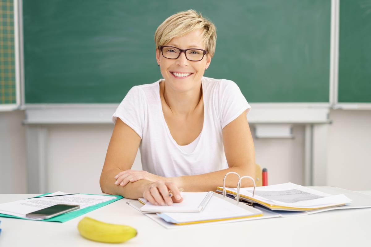 Lehrerin lächelt in die Kamera