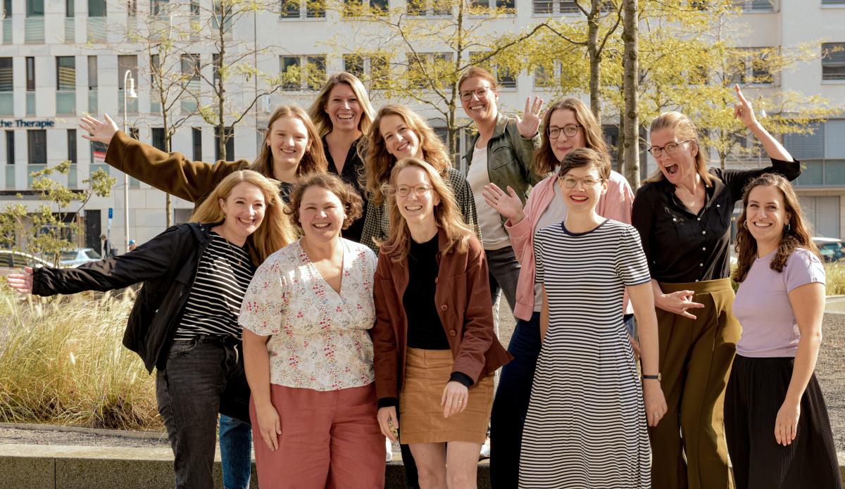 zehn Mitarbeiterinnen des vzbv lachen in die Kamera