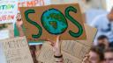 Bei einem Klimastreik wird ein Plakat mit der Aufschrift "SOS" hochgehalten mit der Erdkugel als O.